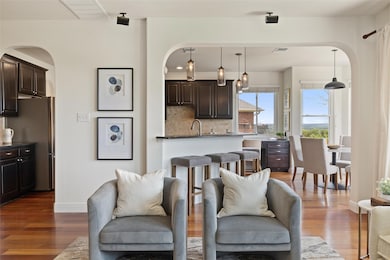 Living room featuring arched walkways, baseboards