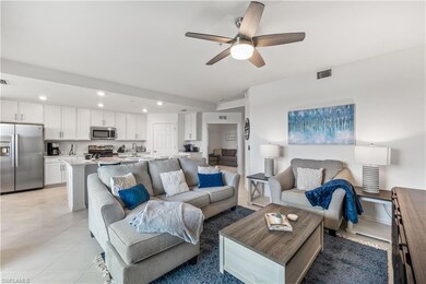 Living room with ceiling fan and light tile floors