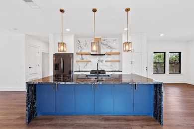 Kitchen featuring dark stone countertops, backspl