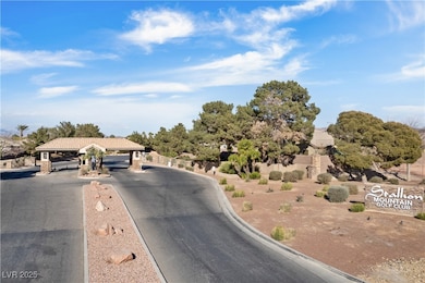 View of asphalt street featuring curbs and a gated