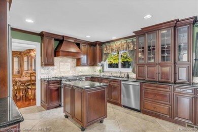 Kitchen featuring premium range hood, decorative backsplash, stainless steel appliances, crown molding, and recessed lighting