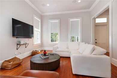 Living room featuring hardwood / wood-style flooring, crown molding, and recessed lighting