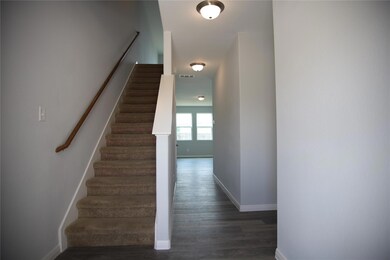 Stairway with wood finished floors and baseboards