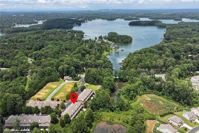 View of property location with a nearby body of water and a heavily wooded area