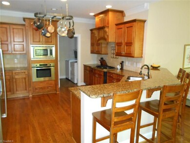 Kitchen with with pot rack, granite counters, stainless Bosch appliances & gas down-draft cooktop