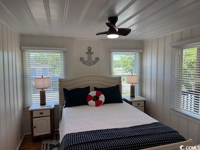 Bedroom with a ceiling fan and dark wood-type flooring