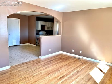 Unfurnished room with light wood-style floors, arc