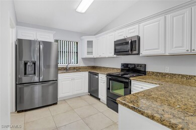 Kitchen featuring lofted ceiling, white cabinetry, sink, and appliances with stainless steel finishes
