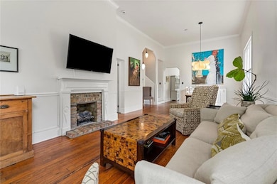 Living area with arched walkways, crown molding, h