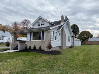 View of side of property with a porch, a chimney, and brick siding