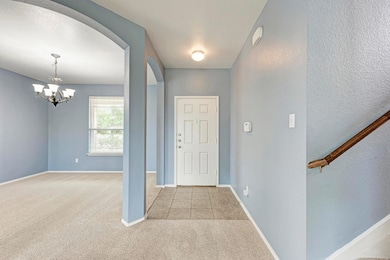 Carpeted entrance foyer featuring arched walkways