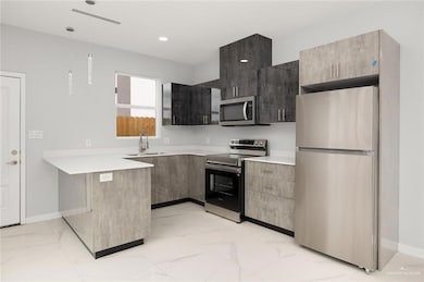 Kitchen featuring appliances with stainless steel finishes and sink