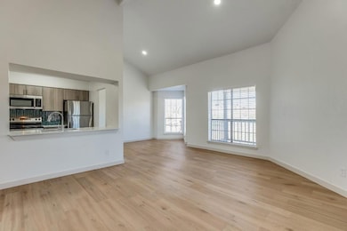 Unfurnished living room with sink, high vaulted ce