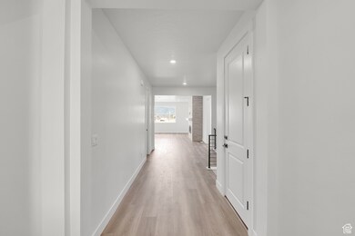 Corridor with light wood finished floors and recessed lighting