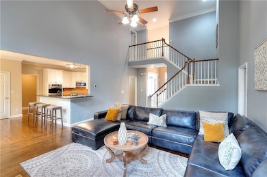 Living area with stairway, ornamental molding, bas