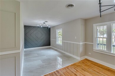 Unfurnished dining area with light wood finished floors, a chandelier, and wood walls