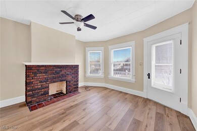 Virtually Staged Unfurnished living room with a fireplace, baseboards, a ceiling fan, and wood finished floors