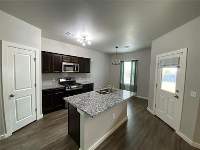 Kitchen featuring visible vents, a sink, dark wood