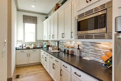 Perimter wall of model plan.  Example of flow of kitchen.  This home with have gay base cabinets with white quartz counter tops and white back splash 