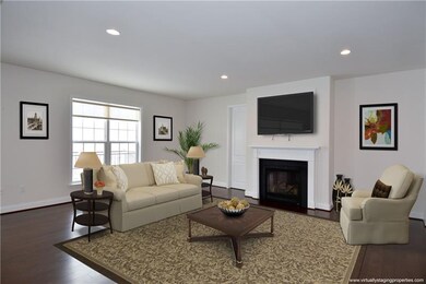 Kitchen area opens to expanded family room with gas fireplace. Note: room was virtually staged.