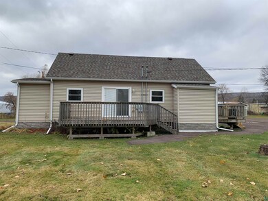 Back of house featuring a deck and a lawn