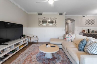 Tiled living room with crown molding and ceiling f