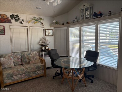 Eat in kitchen with ceiling, wood walls, vaulted ceiling, and a ceiling fan