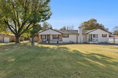 View of front of home featuring a chimney, a porch, and brick siding