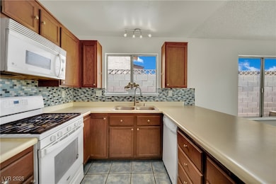 Kitchen featuring white appliances, tasteful backs