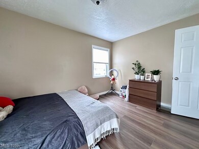 Bedroom featuring hardwood / wood-style flooring and a textured ceiling