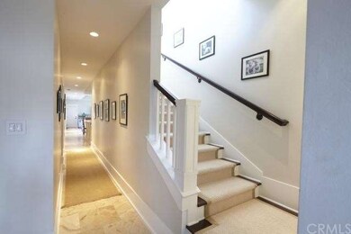 Entry hall with travertine flooring and staircase.