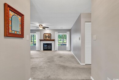 Unfurnished living room featuring plenty of natural light, light carpet, and a textured ceiling