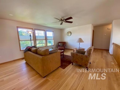 Living room with light wood-type flooring and ceiling fan