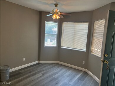 Unfurnished room with ceiling fan and dark wood fi