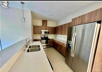 Kitchen with stainless steel appliances, a sink, modern cabinets, brown cabinetry, and light countertops
