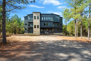 Back of property featuring stone siding and covered porch