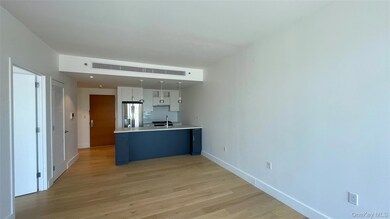 Kitchen featuring white cabinetry, light countertops, backsplash, stainless steel fridge with ice dispenser, and light wood-type flooring