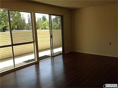 LIving room with wood floors opens to patio with v