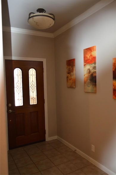 Foyer featuring ornamental molding, tile patterne