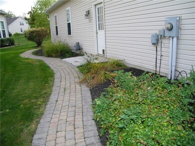 Stone sidewalk and gardens on the garage side of t