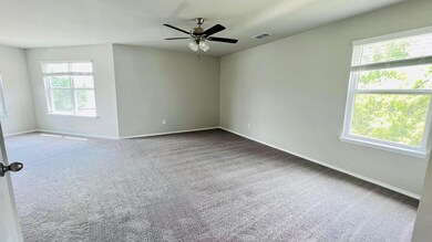 Unfurnished room with light colored carpet and ceiling fan