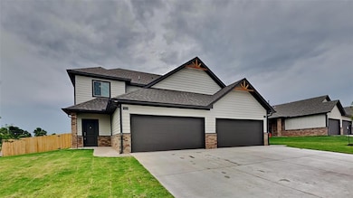 View of front facade with a shingled roof, a garage, concrete driveway, and brick siding