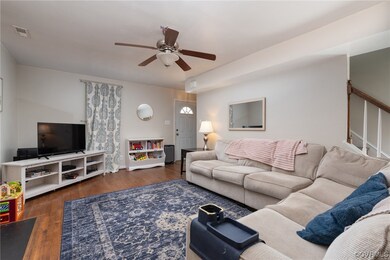 Living room featuring dark wood-type flooring and ceiling fan