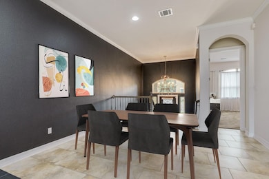Dining room with arched walkways, baseboards, vis