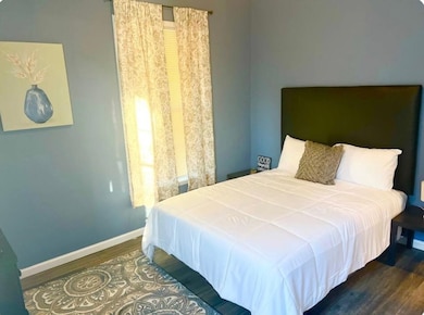 Bedroom featuring wood finished floors and baseboards