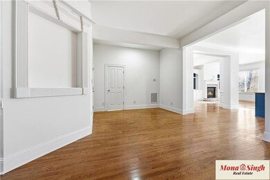 Spare room featuring a glass covered fireplace and wood finished floors