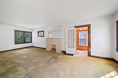 Living room featuring light carpet, a fireplace, a