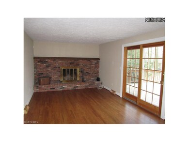 Polished hardwood flooring and a brick fireplace w