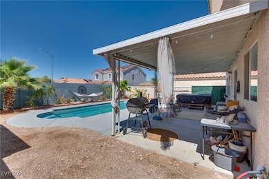 View of pool featuring a patio area and a fenced b