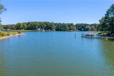 Water view featuring a boat dock and a heavily wooded area